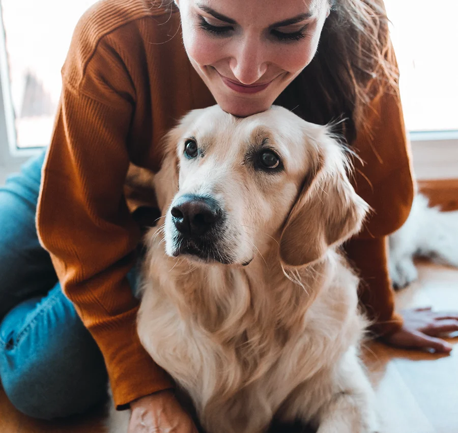 A woman resting her chin on her dog's head