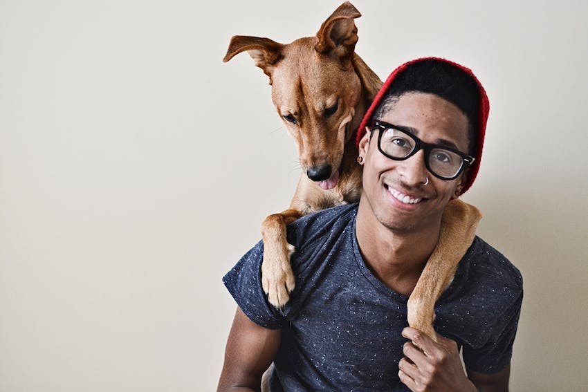 A male pet owner helping his dog with separation anxiety.