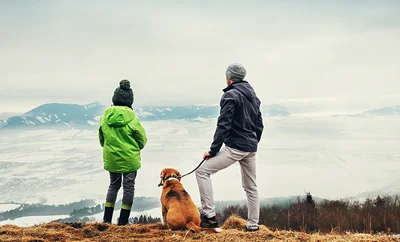 Two people and a dog admire the view